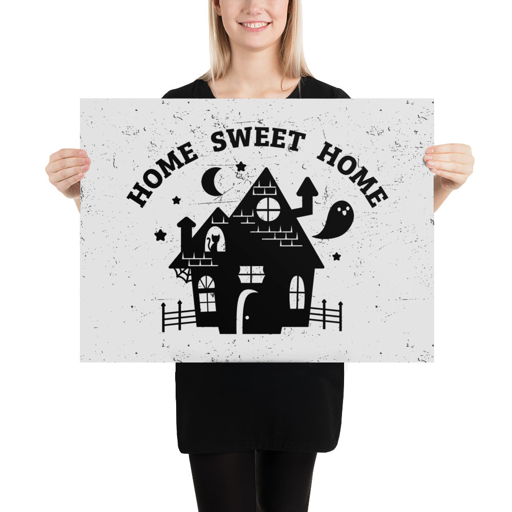 A print of the silhouette of a haunted house. A ghost is flying nearby and a cat is visible in a window. Text above the house reads "HOME SWEET HOME".
