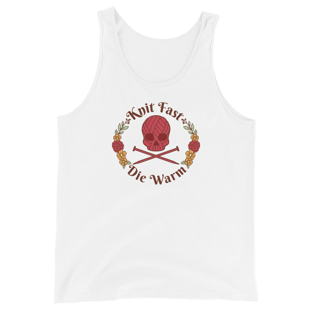 A white tank top featuring an image of a skull and crossbones made of yarn and knitting needles. A floral wreath surrounds the skull, along with words that read "Knit Fast, Die Warm"