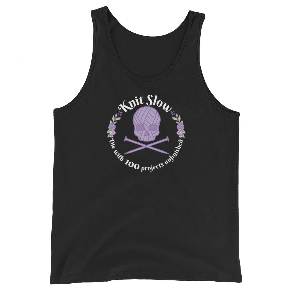 A black tank top featuring an image of a skull and crossbones made of yarn and knitting needles. A floral wreath surrounds the skull, along with words that read "Knit Slow, Die with 100 projects unfinished"