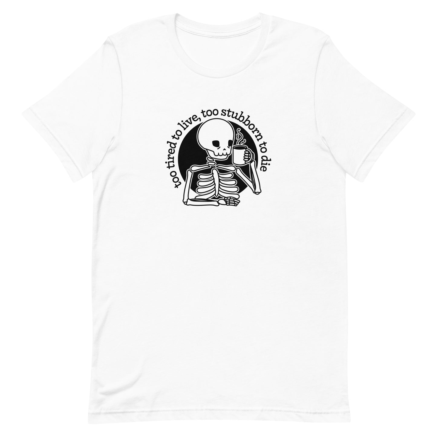 A white crewneck t-shirt featuring a tired-looking skeleton holding a steaming mug. Text in an arc above the skeleton reads "too tired to live, too stubborn to die".