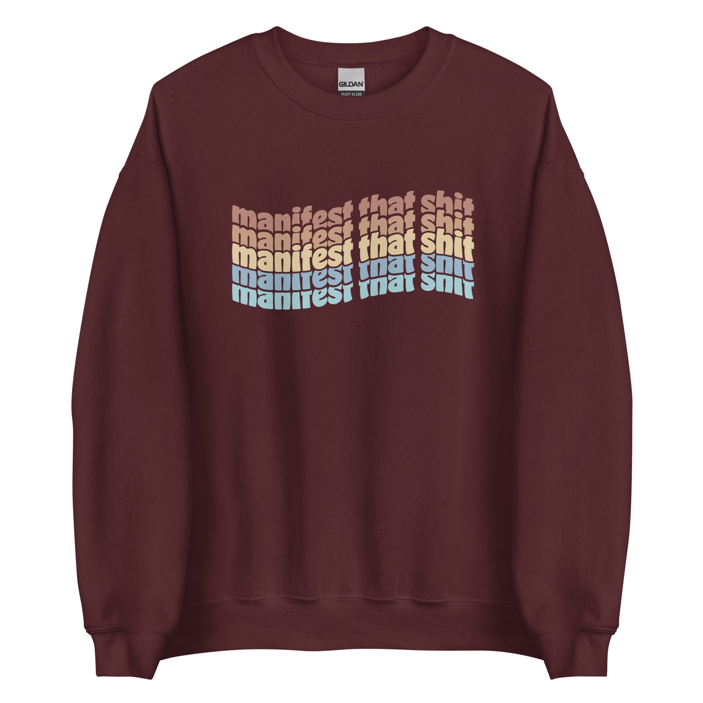 A maroon crewneck sweatshirt featuring stacked text that reads "manifest that shit" in a rainbow of colors.