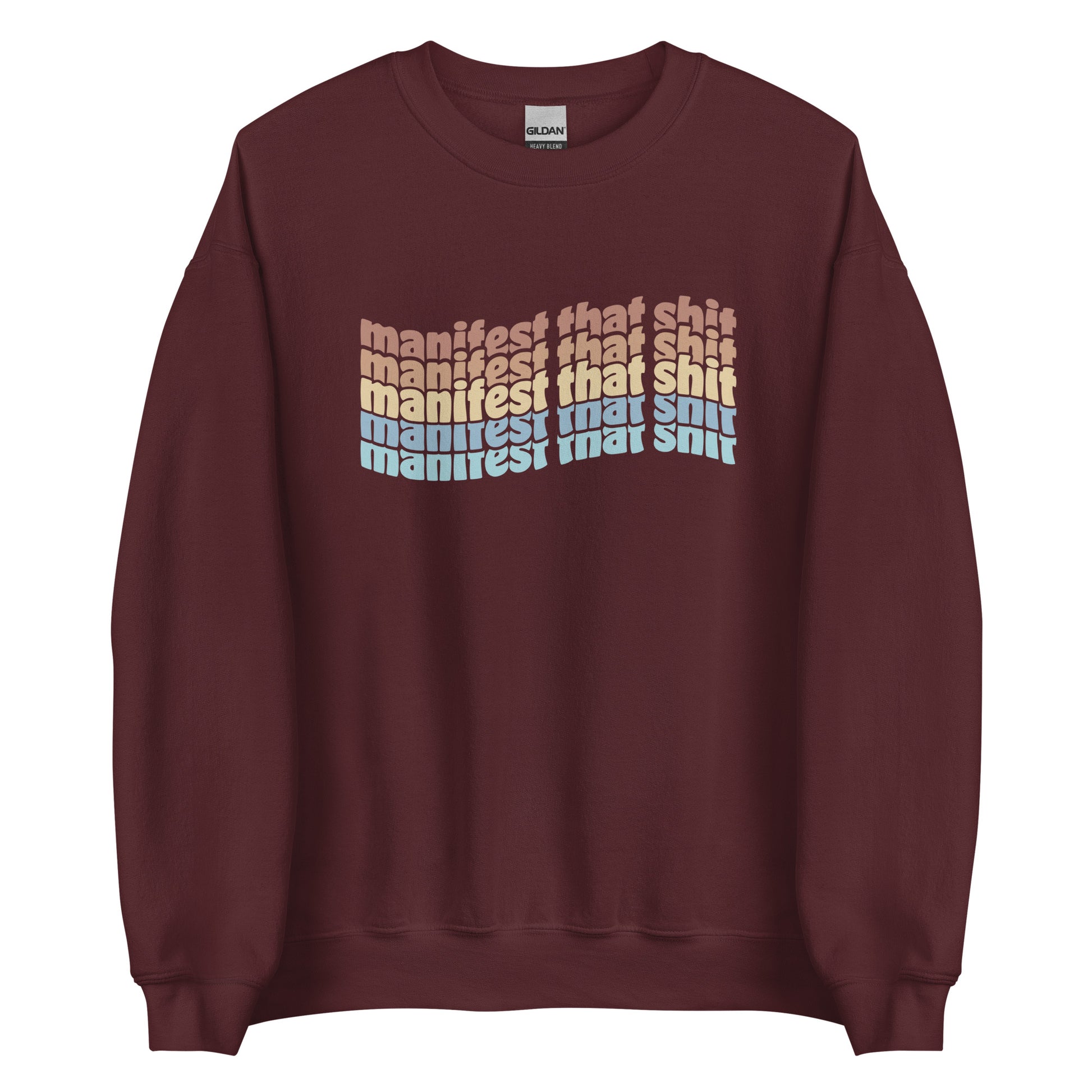 A maroon crewneck sweatshirt featuring stacked text that reads "manifest that shit" in a rainbow of colors.