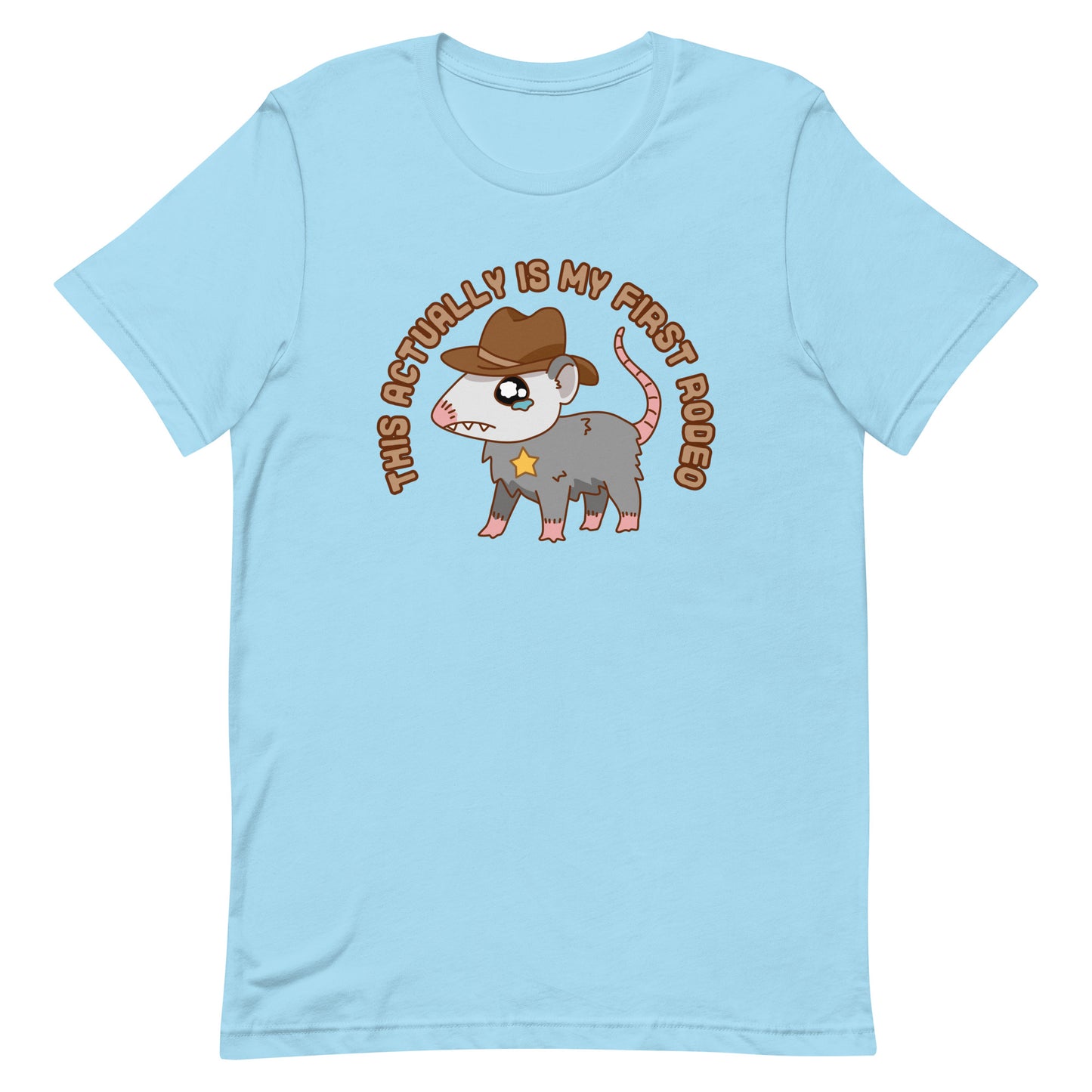 A blue crewneck t-shirt featuring an illustration of a cute and nervous possum wearing a cowboy hat and sherrif's star badge. Text above the possum in an arc reads "this actually is my first rodeo".