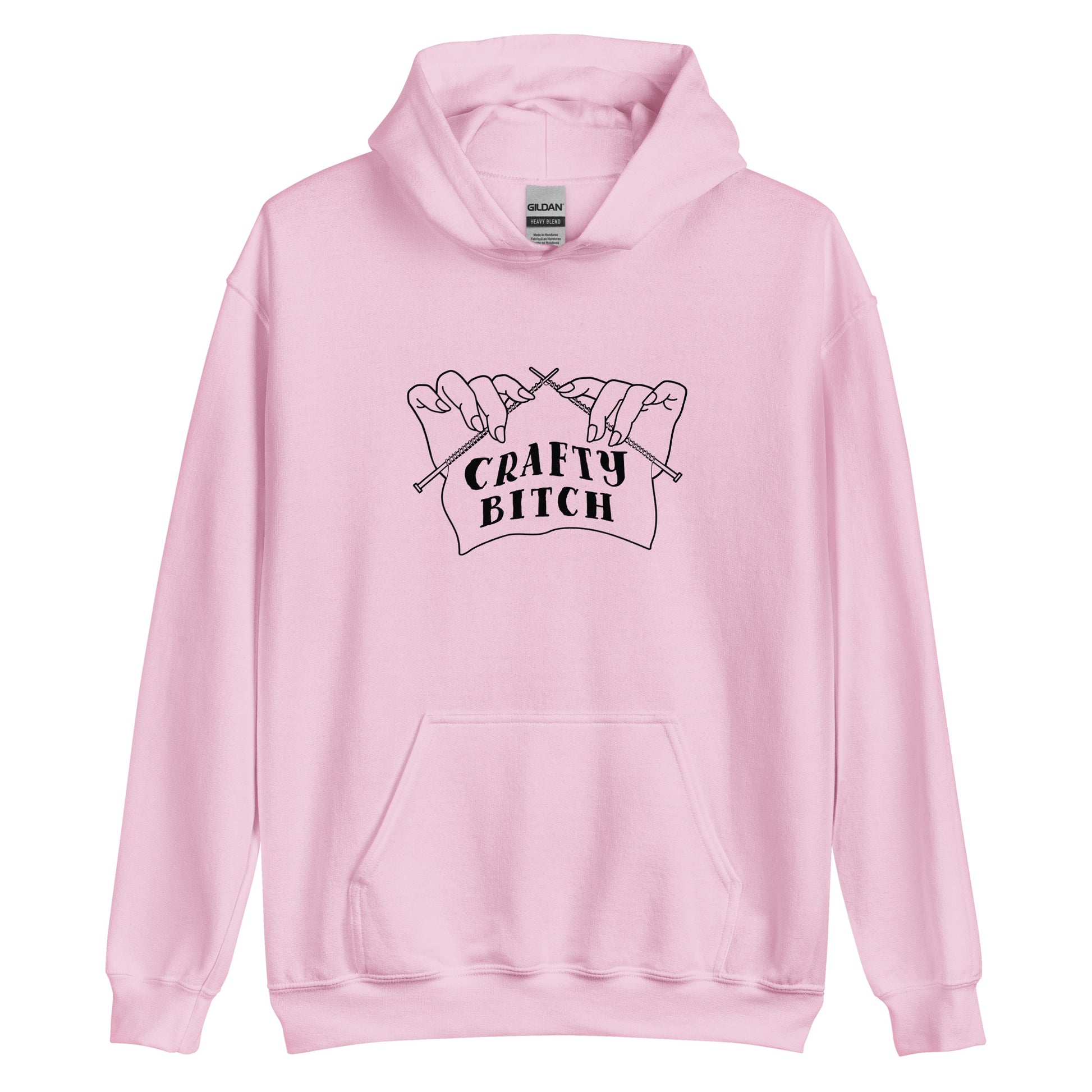 A light pink hooded sweatshirt featuring a single-color illustration of a pair of hands holding knitting needles. Fabric on the needles features text that reads "crafty bitch".