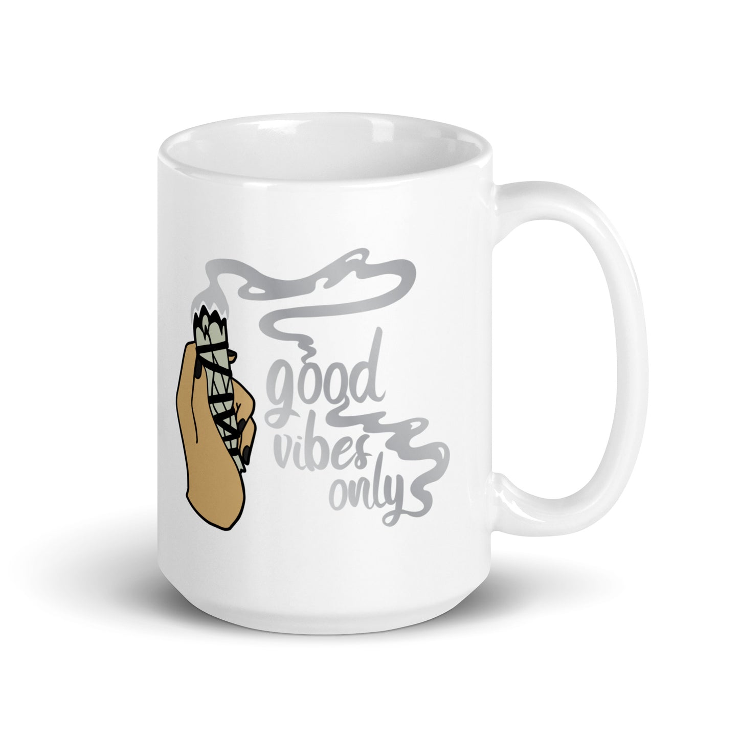 A 15 ounce white ceramic coffee mug featuring an illustration of a hand holding a sage smudge stick. Smoke flows from the tip of the sage and forms words that read "good vibes only"