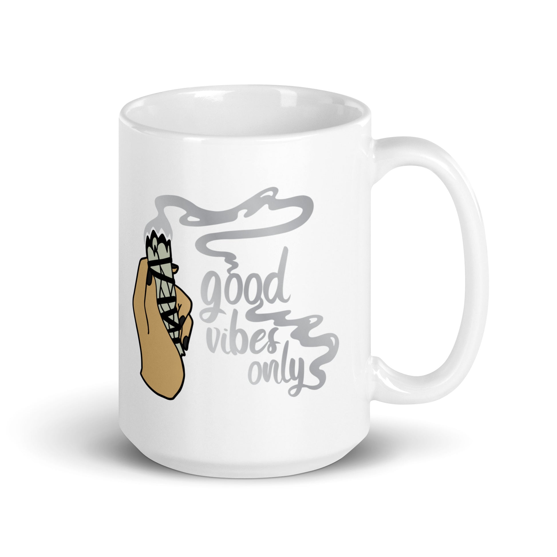 A 15 ounce white ceramic coffee mug featuring an illustration of a hand holding a sage smudge stick. Smoke flows from the tip of the sage and forms words that read "good vibes only"