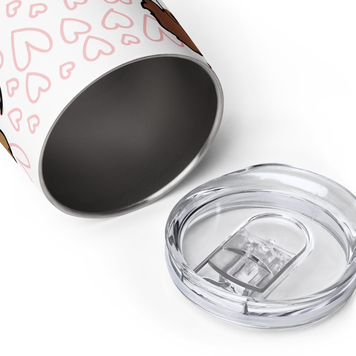 A white metal wine tumbler laying on its side, with the opening facing the viewer. The clear plastic lid is laying nearby.