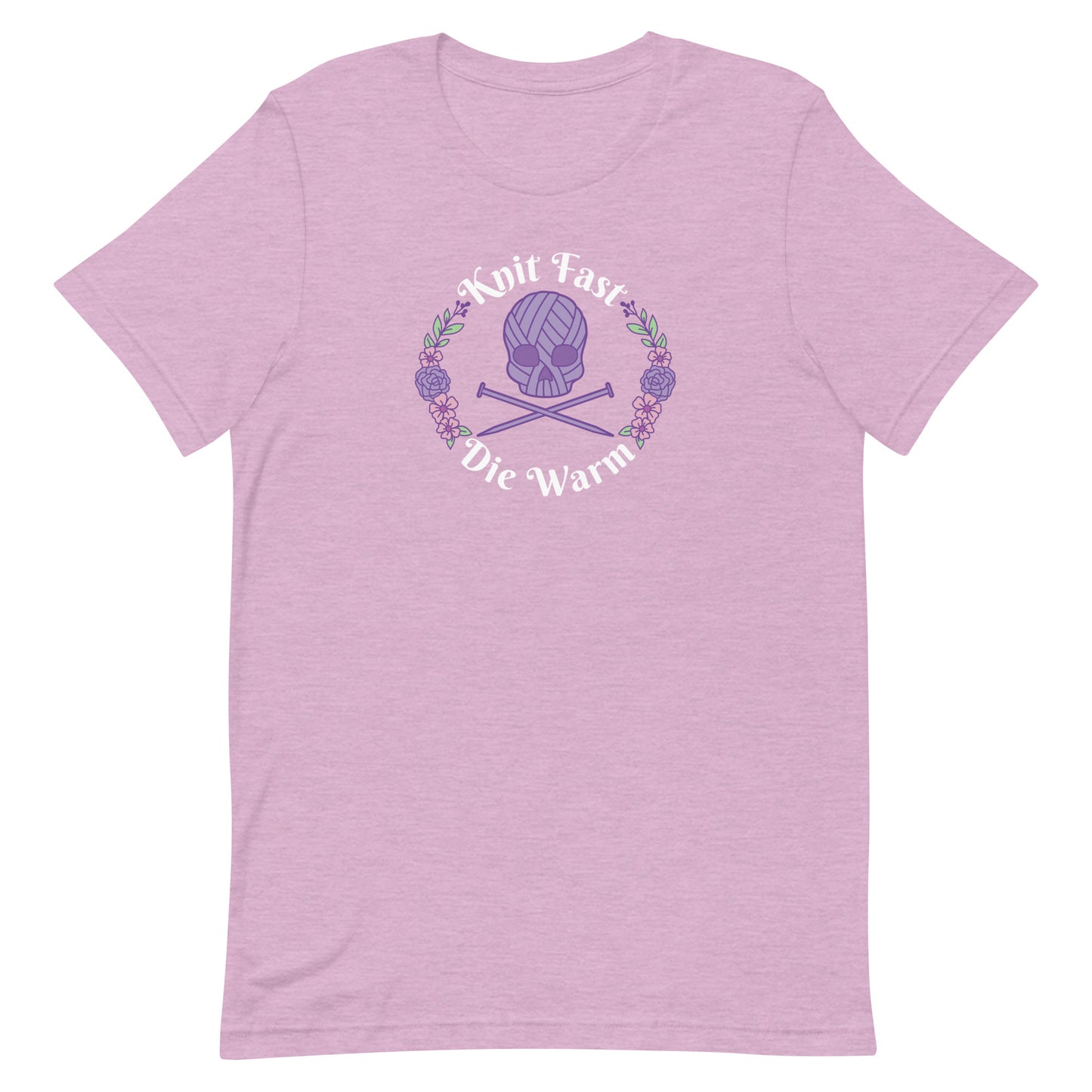 A heathered pink crewneck t-shirt featuring an image of a skull and crossbones made of yarn and knitting needles. A floral wreath surrounds the skull, along with words that read "Knit Fast, Die Warm"