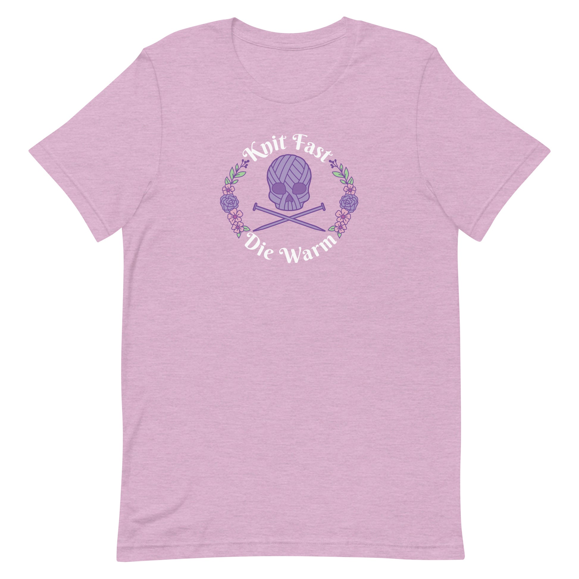A heathered pink crewneck t-shirt featuring an image of a skull and crossbones made of yarn and knitting needles. A floral wreath surrounds the skull, along with words that read "Knit Fast, Die Warm"