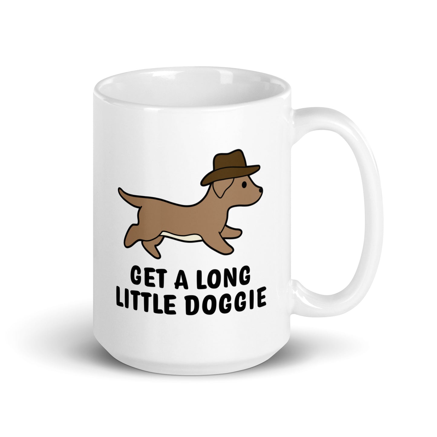 A white 15 ounce ceramic mug featuring an image of a dachshund wearing a cowboy hat. Text below the dog reads "Get a long little doggie"