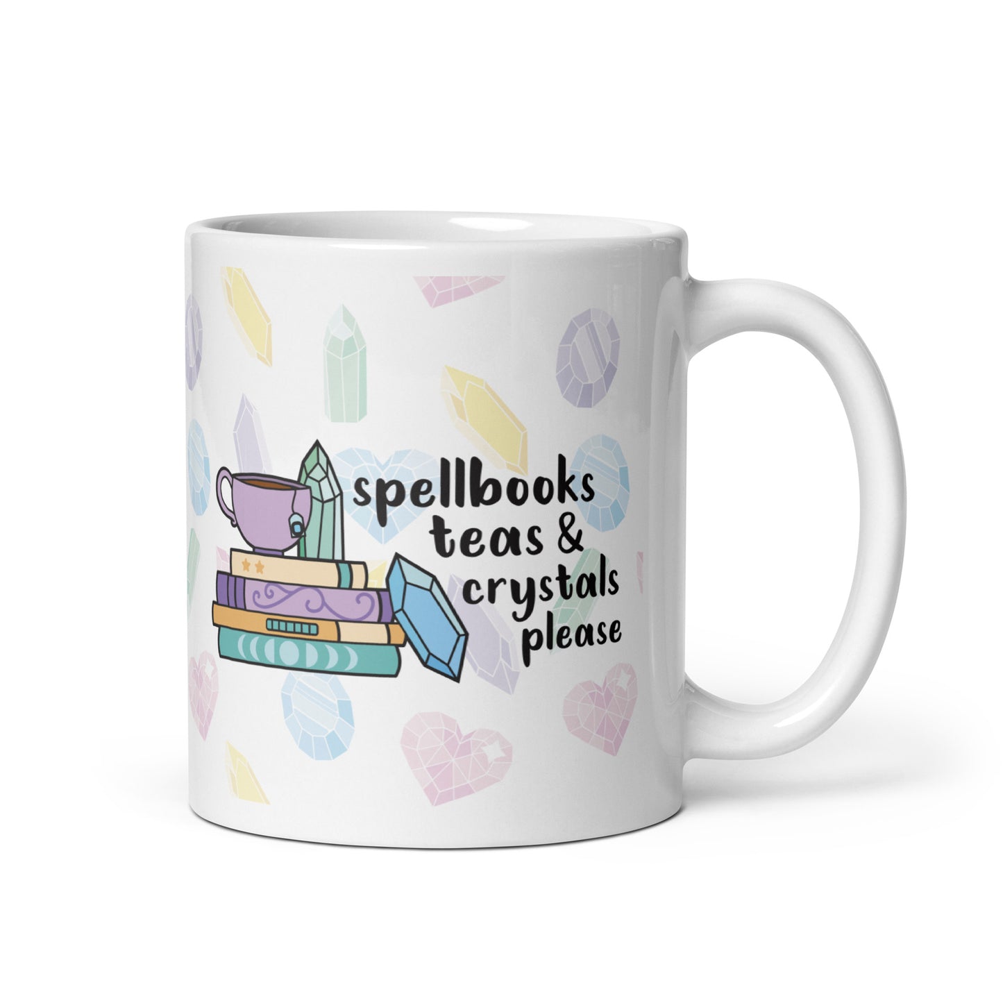 A white 11 ounce ceramic mug with a pattern of pastel crystals. In the center of the mug is an illustration of several books and crystals and a teacup. Text along side the image reads "Spellbooks, teas, & crystals please"