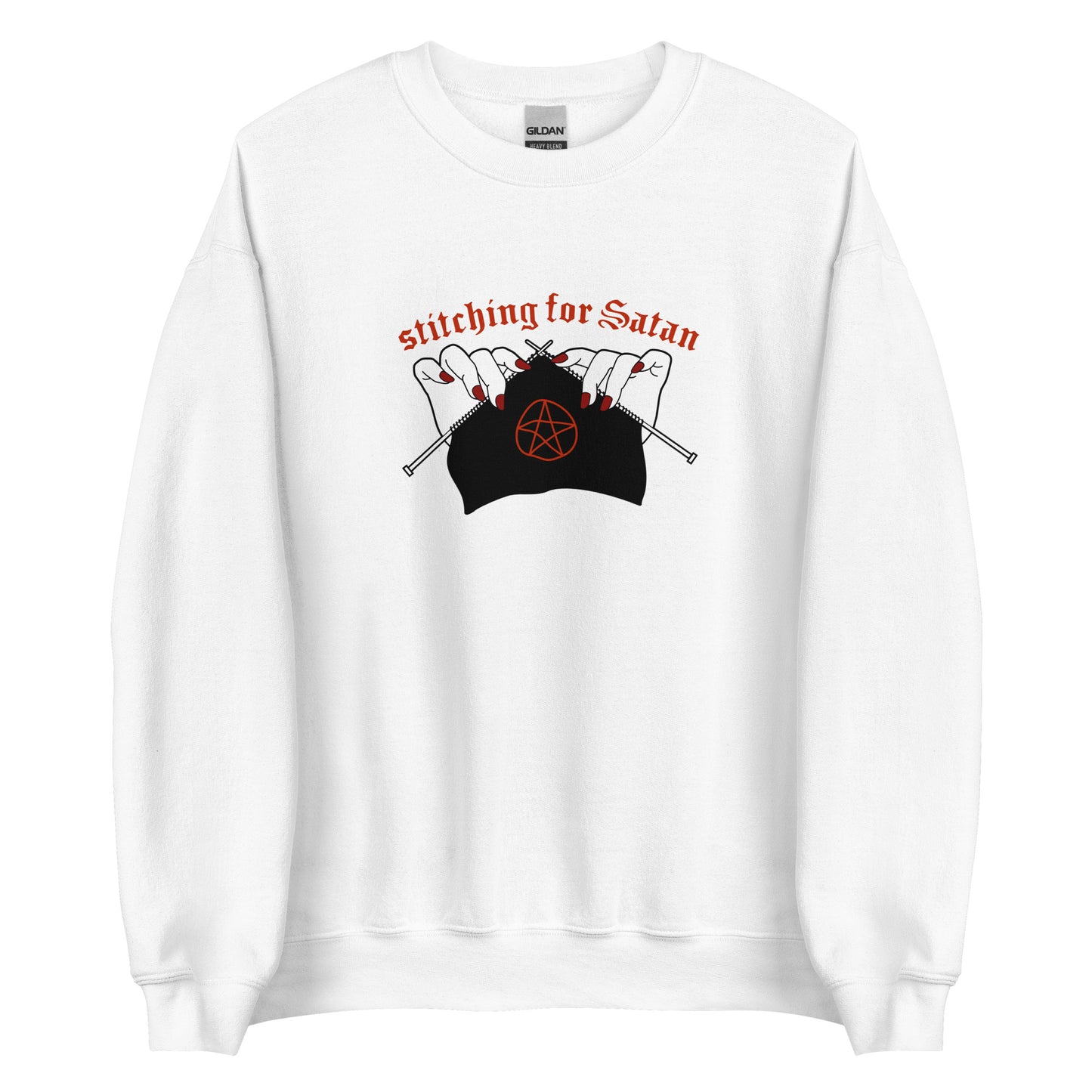 A white crewneck sweatshirt featuring an illustration of pale white hands with red fingernails holding knitting needles. Fabric on the needles features a red pentagram. Text above the hands reads "stitching for Satan" in a gothc red font.