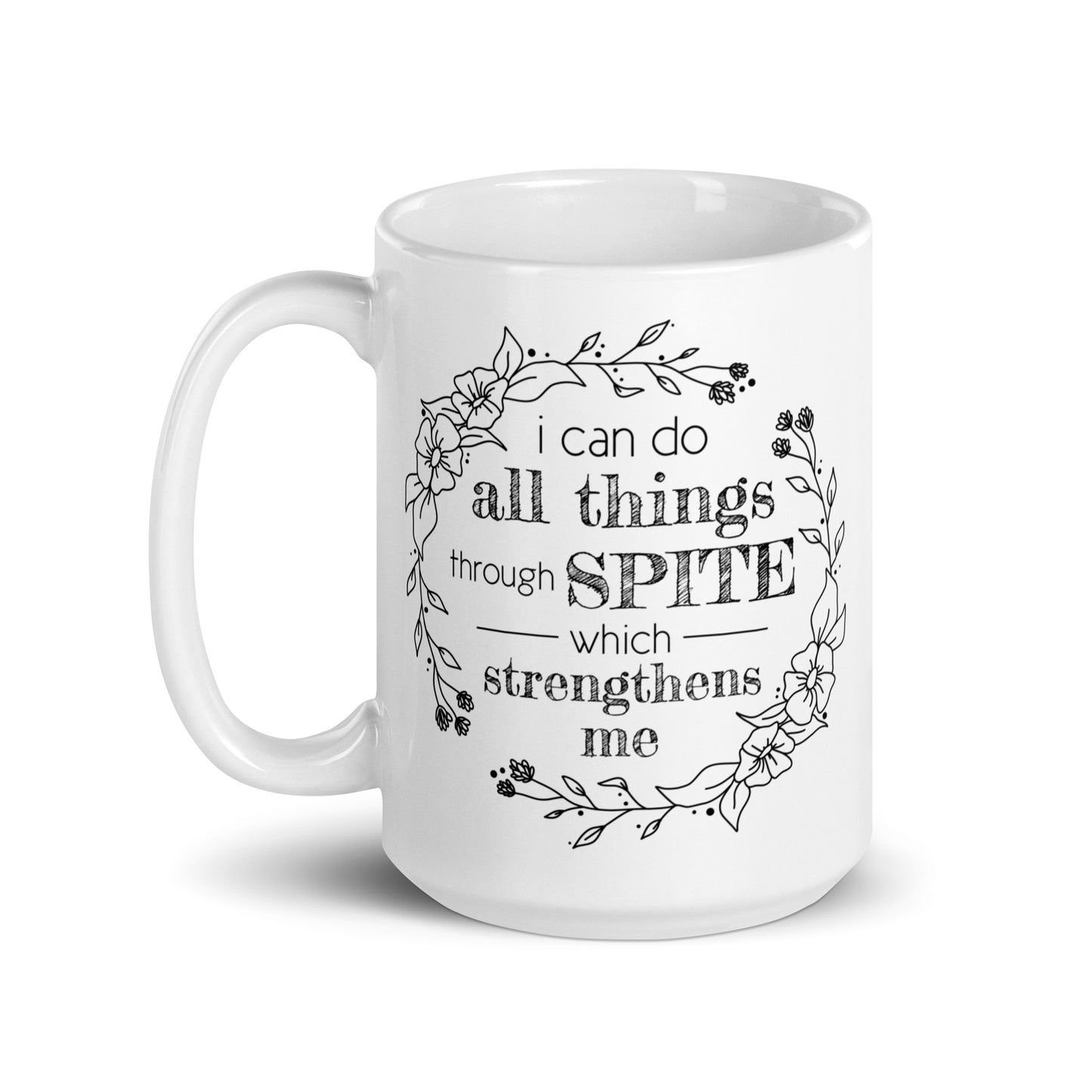 A white ceramic mug featuring a simple illustration of a floral wreath. Inside the wreath is text that reads "I can do all things through SPITE which motivates me"