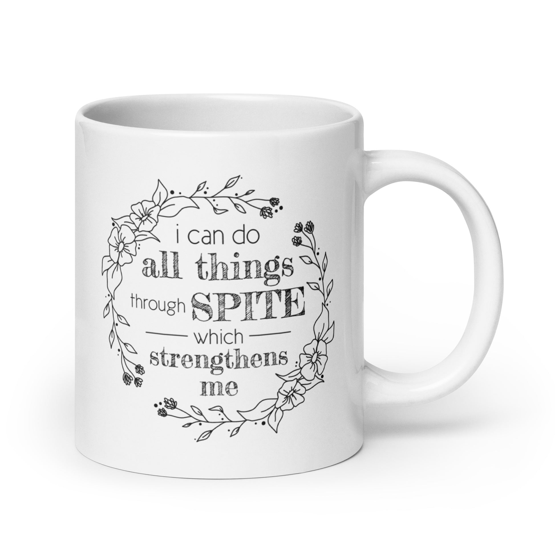 A white ceramic mug featuring a simple illustration of a floral wreath. Inside the wreath is text that reads "I can do all things through SPITE which motivates me"