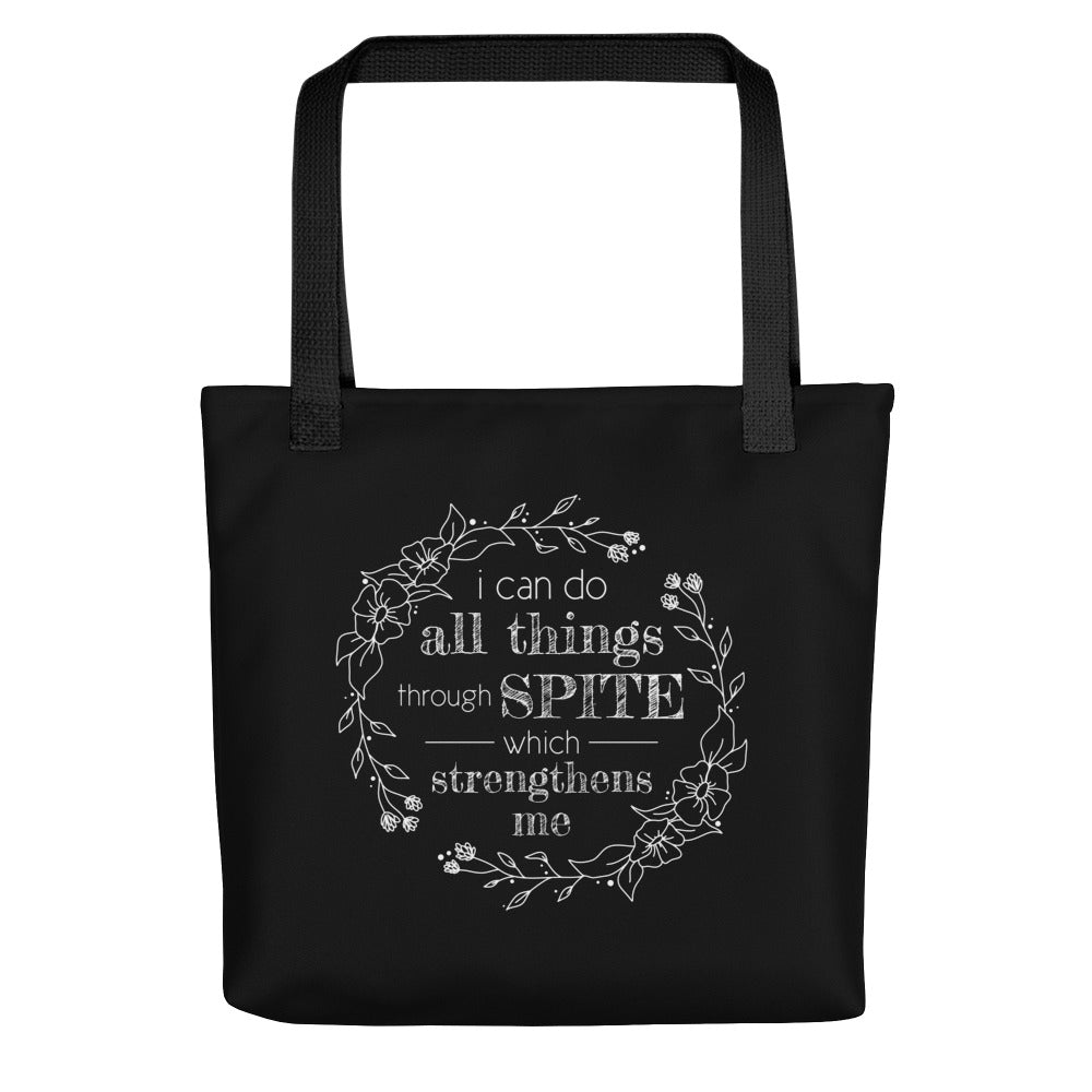 A blacktote bag with black handles, featuring a simple illustration of a floral wreath. Inside the wreath is text that reads "I can do all things through SPITE which motivates me"