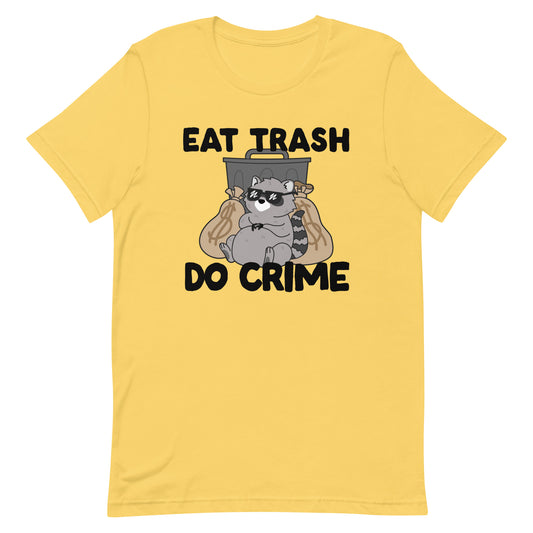 A yellow crewneck t-shirt featuing an illustration of a chubby raccoon wearing sunglasses. The raccoon is laying back against a trash can and large bags of money. Text surrounding the image reads "Eat trash. Do crime."