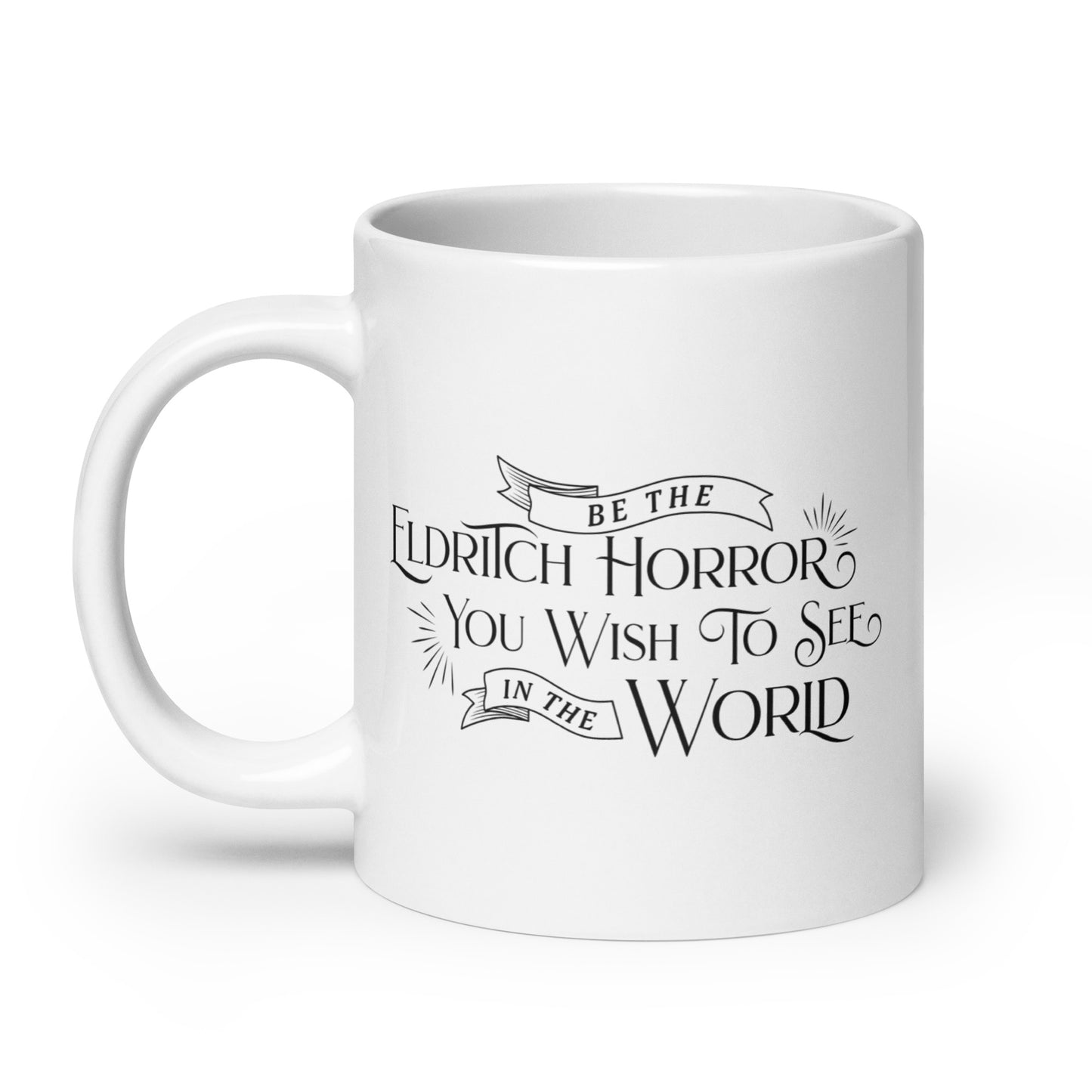 A white, ceramic, 20 ounce mug featuring black text in a semi-gothic style font that reads "Be the Eldritch Horror You Wish To See In The World"