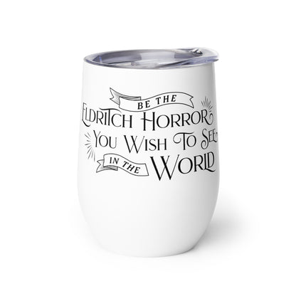 A white wine tumbler with a plastic lid. The wine tumbler is decorated with black text in a semi-gothic style font that reads "Be the Eldritch Horror You Wish To See In The World"