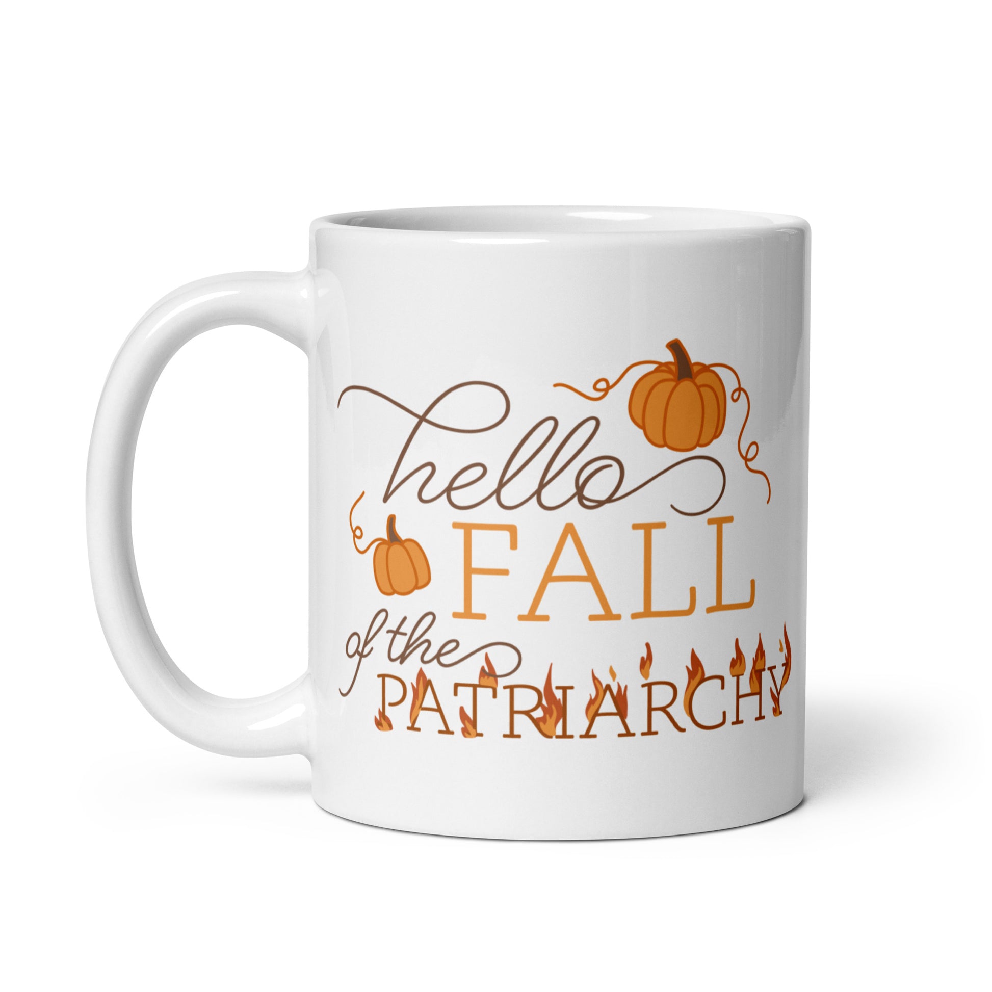A white ceramic coffee mug featuring text in a blend of cursive and serif fonts that read "hello FALL of the PATRIARCHY". Pumpkins surround the upper half of the text, and the word "Patriarchy" is surrounded by flames.