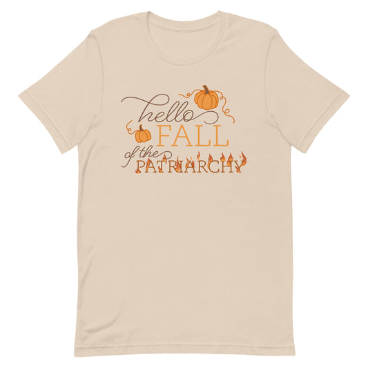 A cream-colored crewneck t-shirt featuring text that reads "Hello fall of the patriarchy". Pumpkins surround the first half of the text and the word "patriarchy" is on fire.