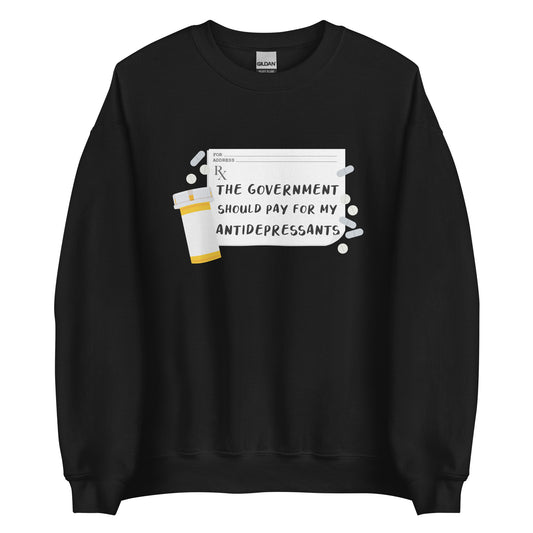 A black crewneck sweatshirt featuring an image of a subscription page with text that reads "The government should pay for my antidepressants". Pills and an empty orange pill bottle surround the RX sheet.