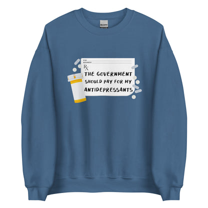 A blue crewneck sweatshirt featuring an image of a subscription page with text that reads "The government should pay for my antidepressants". Pills and an empty orange pill bottle surround the RX sheet.