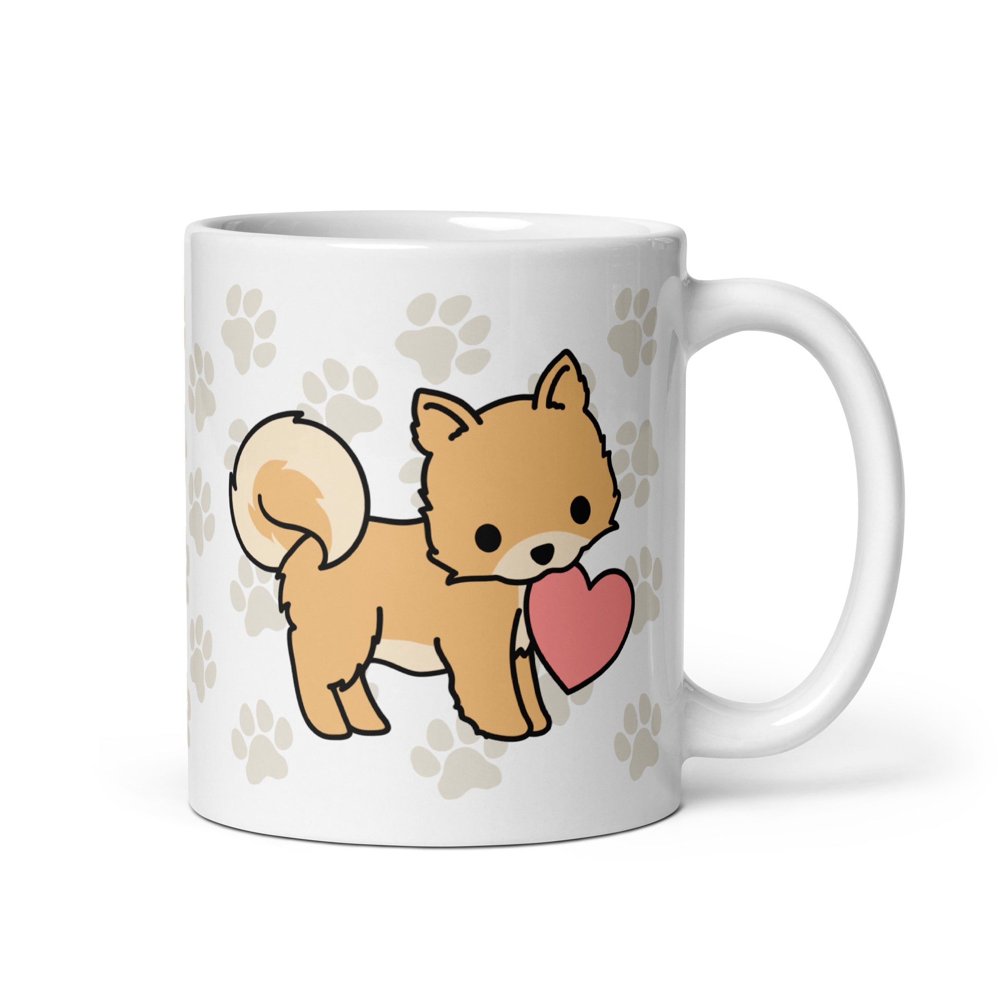 A white 11 ounce ceramic mug with a pattern of light brown pawprints all over. The mug also features a stylized illustration of a Pomeranian holding a heart in its mouth.