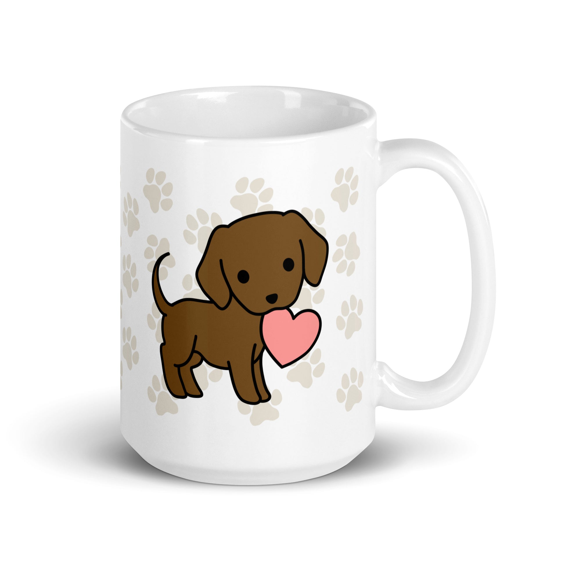 A white 15 ounce ceramic mug with a pattern of light brown pawprints all over. The mug also features a stylized illustration of a Chocolate Lab holding a heart in its mouth.
