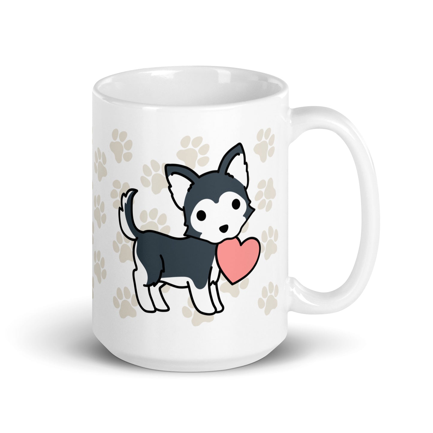 A white 15 ounce ceramic mug with a pattern of light brown pawprints all over. The mug also features a stylized illustration of a Husky holding a heart in its mouth.