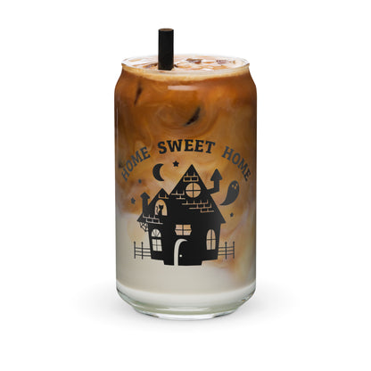 A 16 ounce glass can, filled with iced coffe, featuring a black silhouette of a haunted house. Text above the house in an arc reads "Home Sweet Home"