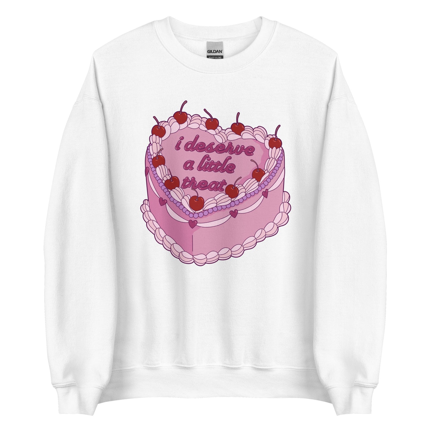 A white crewneck sweatshirt featuring an illustration of an elaborately decorated pink cake. Icing on the cake reads "i deserve a little treat" in a cursive font.