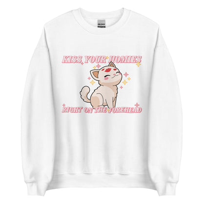 A white crewneck sweatshirt featuring an illustration of a soft white kitten. Lipstick kiss marks are on the kitten's forehead, and its face is surrounded by sparkles. Pink text around the kitten reads "Kiss your homies right on the forehead."