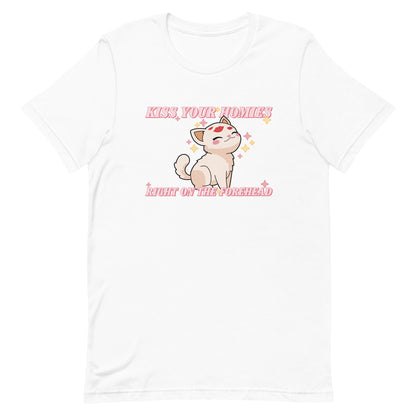 A white crewneck t-shirt featuring an illustration of a soft white kitten. Lipstick kiss marks are on the kitten's forehead, and its face is surrounded by sparkles. Pink text around the kitten reads "Kiss your homies right on the forehead."