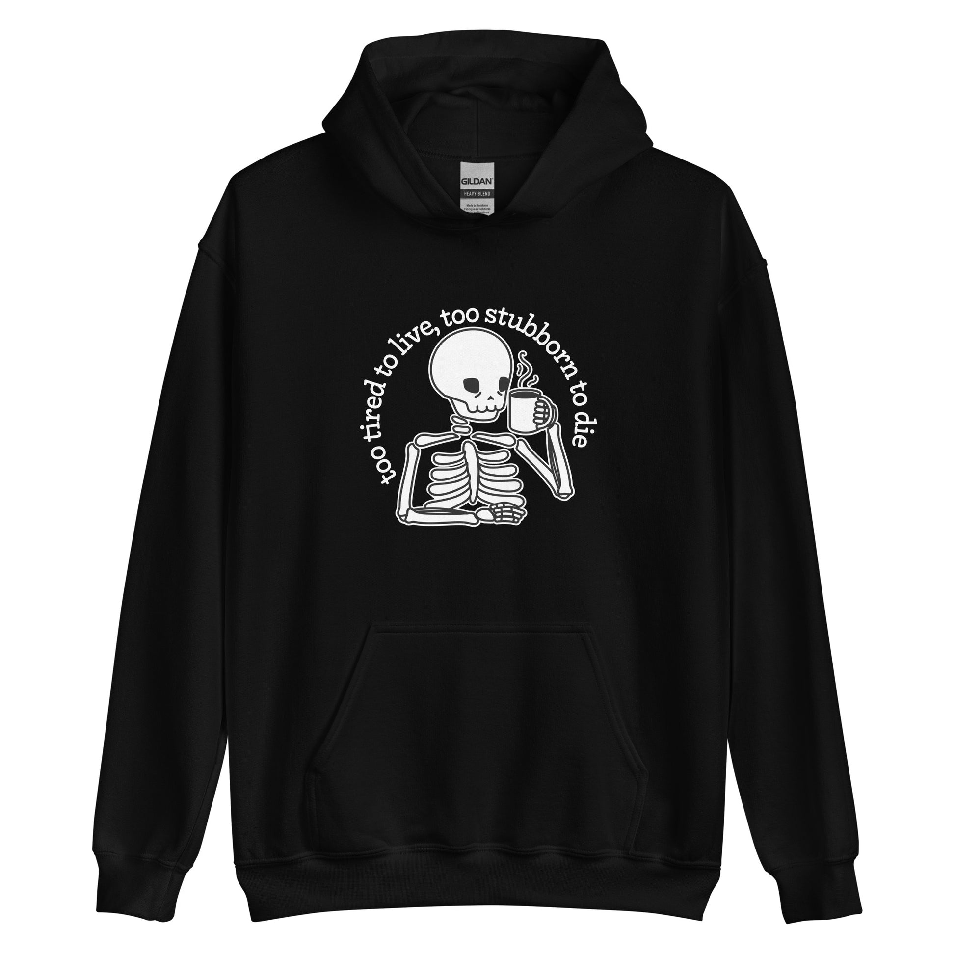 A black hooded sweatshirt featuring an illustration of a tired-looking skeleton holding a steaming mug. Text in an arc above the skeleton reads "too tired to live, too stubborn to die"