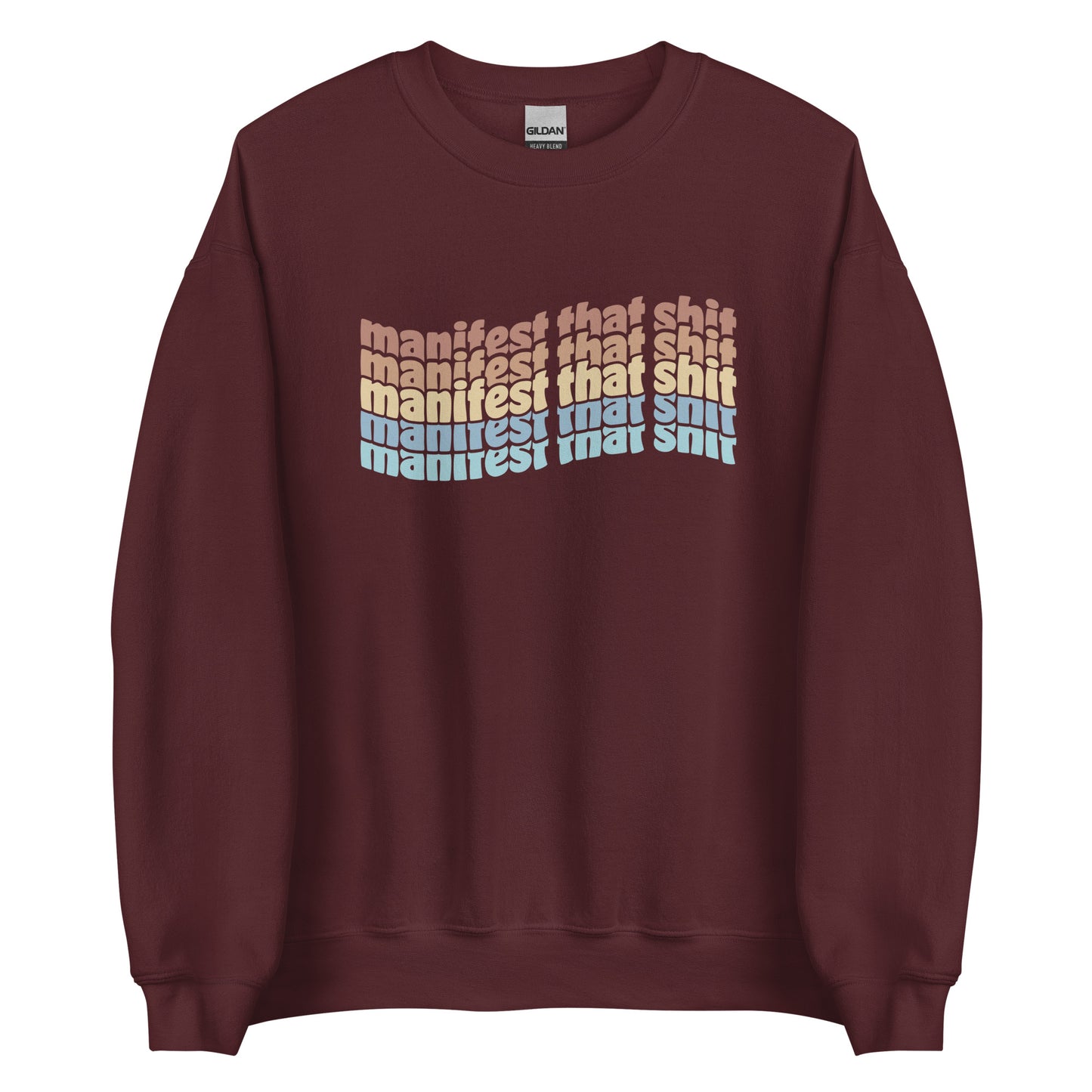 A maroon crewneck sweatshirt featuring stacked text that reads "manifest that shit" in a rainbow of colors.