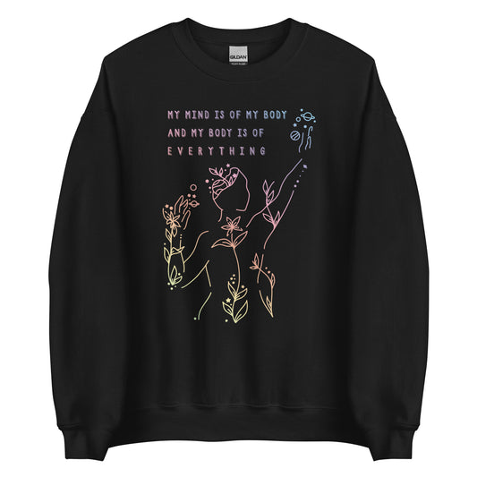 A black crewneck sweatshirt featuring an abstract illustration of a figure whose body is spreading out into plants and planets and stars. Text above the figure reads "My mind is of my body and my body is of everything."