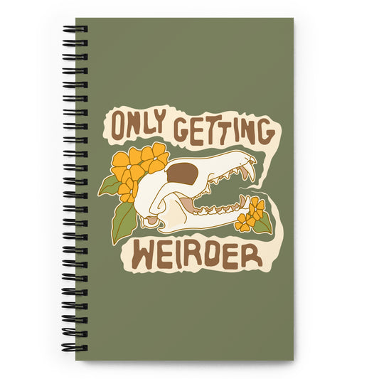 An olive green o-ring bound notebook featuring an illustration of a fox skull surrounded by yellow flowers. Wobbly speech bubbles are coming from the fox's mouth. The text inside the bubbles reads "ONLY GETTING WEIRDER".