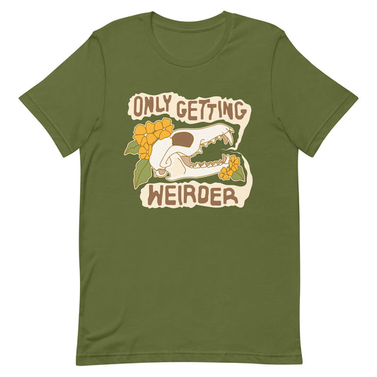 An olive green t-shirt featuirng an illustration of a fox skull surrounded by yellow flowers. Wobbly speech bubbles are coming from the fox's mouth. Text inside the bubbles reads "ONLY GETTING WEIRDER'.