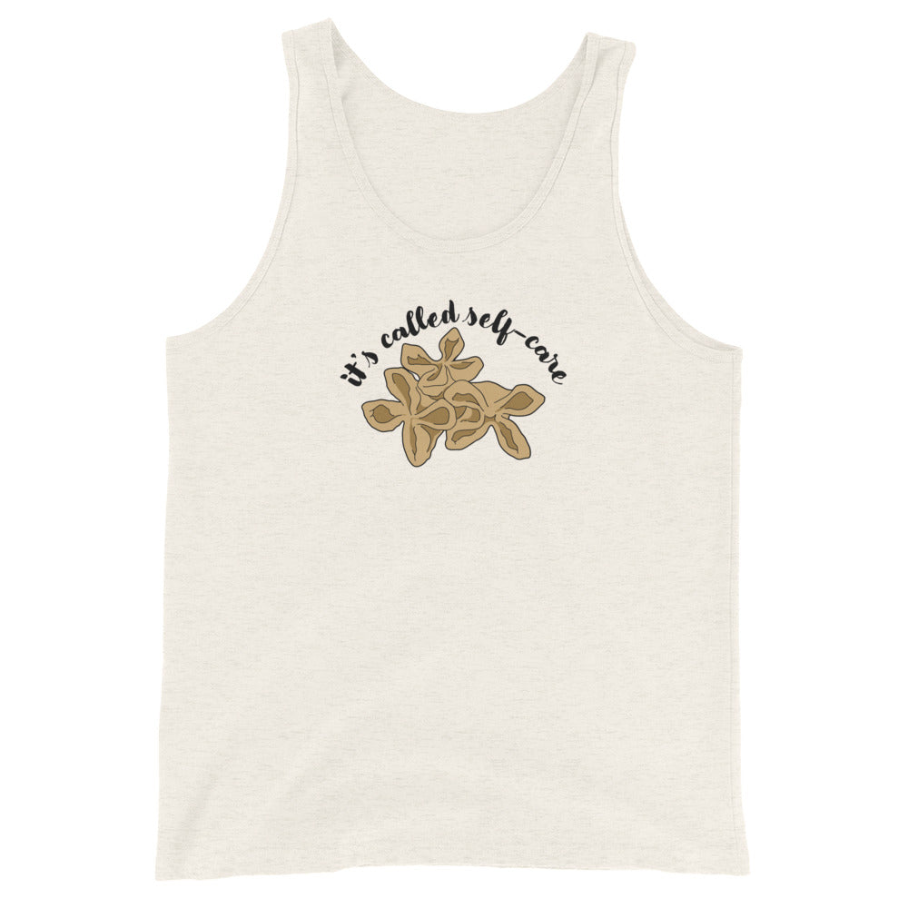 A cream-colored tank top featuring an illustration of three pieces of crab rangoon. Text in an arc above the crab rangoon reads "it's called self-care" in a cursive script.