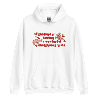 A white hooded sweatshirt featuring an illustration of two festive shrimp - one with a Santa hat, and one with reindeer antlers. Text between the shrimp reads "shrimply having a wonderful Christmas time".