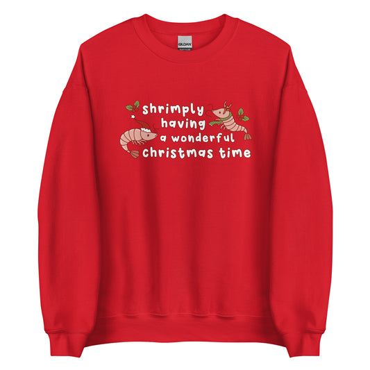 A red crewneck sweatshirt featuring an illustration of two festive shrimp - one with a Santa hat, and one with reindeer antlers. Text between the shrimp reads "shrimply having a wonderful Christmas time".