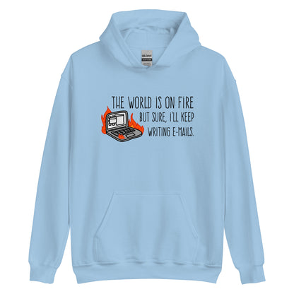 A light blue hooded sweatshirt featuring a squiggly illustration of a laptop that is on fire. Text alongside the laptop reads "the world is on fire but sure, I'll keep writing e-mails."