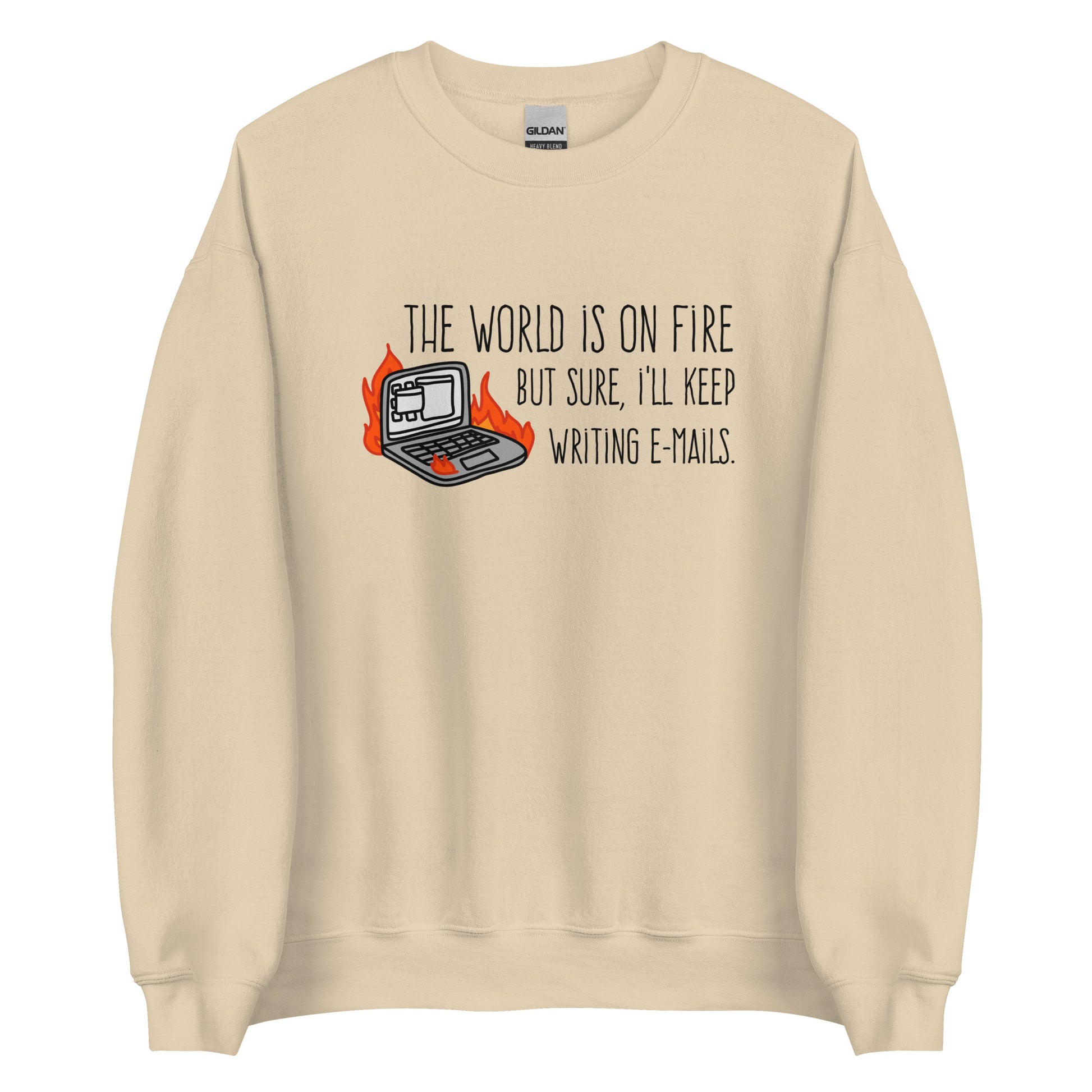 A tan crewneck sweatshirt featuring a squiggly illustration of a laptop that is on fire. Text alongside the laptop reads "the world is on fire but sure, I'll keep writing e-mails."