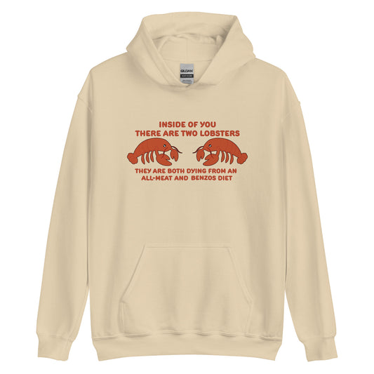 A beige hooded sweatshirt featuring an illustration of two lobsters. Text around the lobster reads "Inside Of You There Are Two Lobsters" "They are both dying from an all-meat and benzos diet."