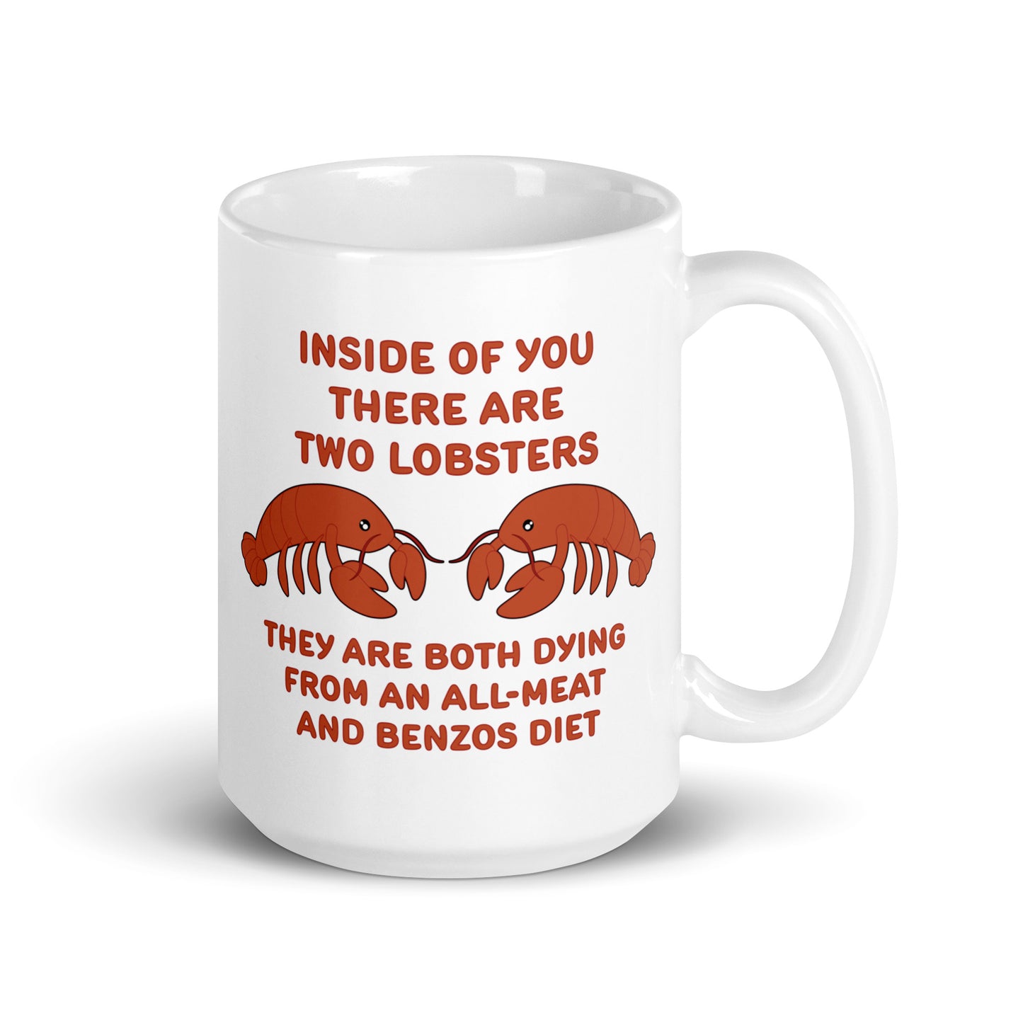 A white 15 ounce ceramic mug featuring an illustration of two lobsters. Text around the lobsters reads "Inside of you there are two lobsters." "They are both dying from an all-meat and benzos diet."