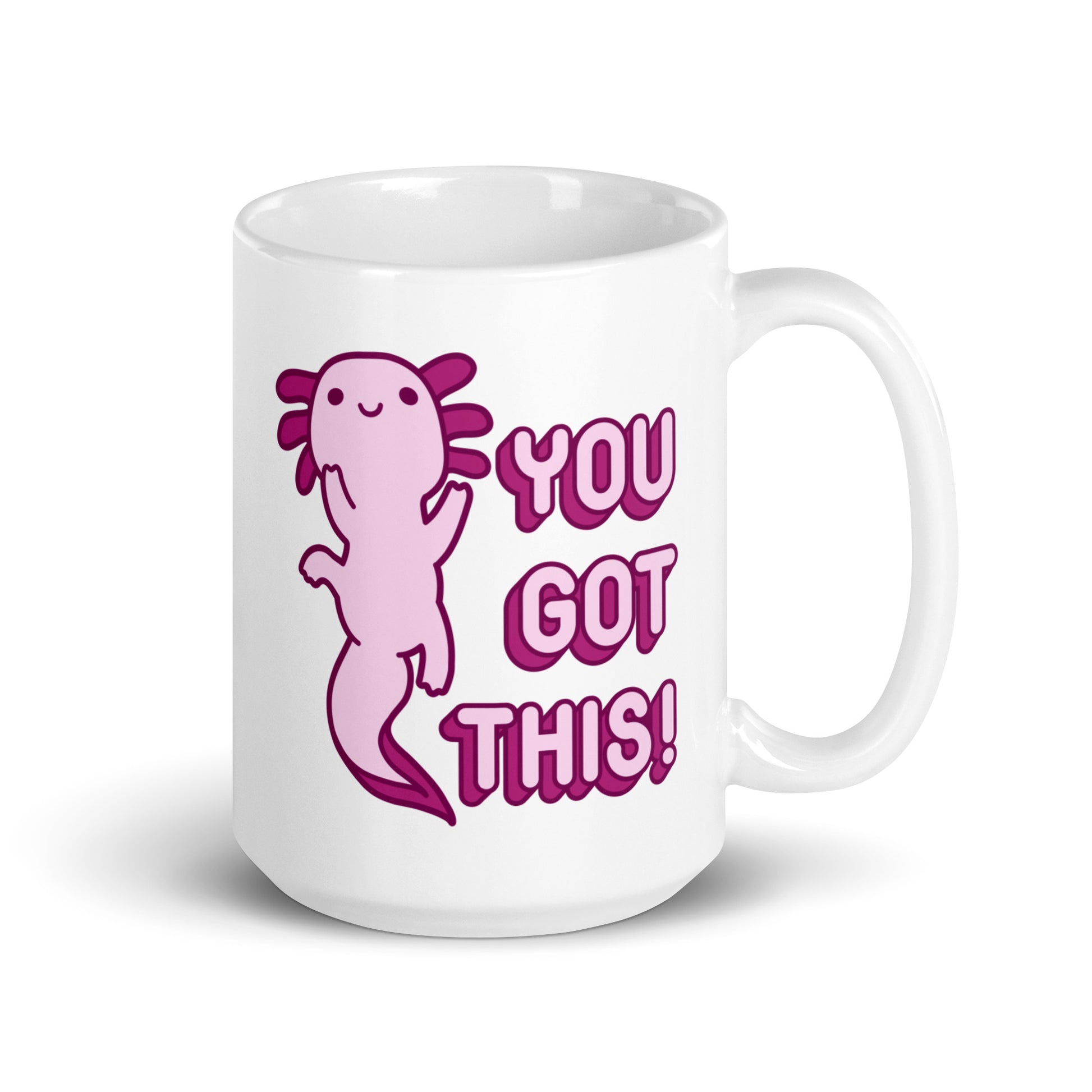 A 15 oz white coffee mug with the handle on the right-hand side with a picture of a pink axolotl and the words "You Got This!" in pink bubble letters
