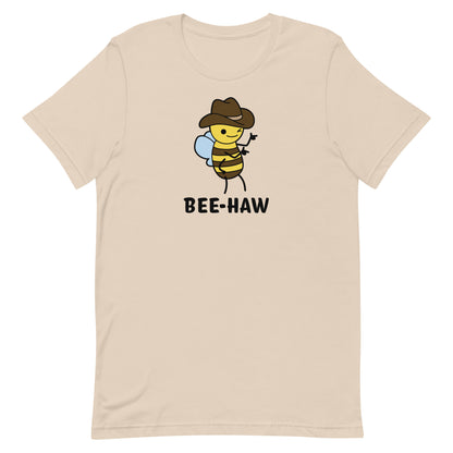 A beige crewneck t-shirt with an image of a bee in a cowboy hat. The bee is winking and holding up "finger guns". Underneath the bee is text reading "Bee-Haw"