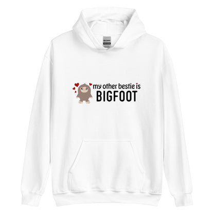 A white hooded sweatshirt featuring a cutesy illustration of Bigfoot surrounded by hearts. Text next to Bigfoot reads "my other bestie is Bigfoot"