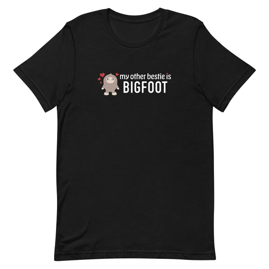 A black crewneck t-shirt featuring a cutesy illustration of Bigfoot, surrounded by hearts. Text alongside Bigfoot reads "my other bestie is Bigfoot"