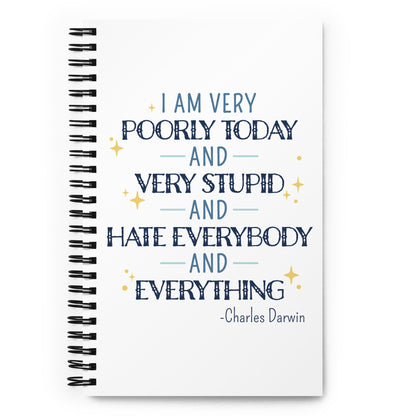 A white wirebound notebook with a quote from Charles Darwin on the cover in blue text. The quote reads "I am very poorly today and very stupid and hate everybody and everything".